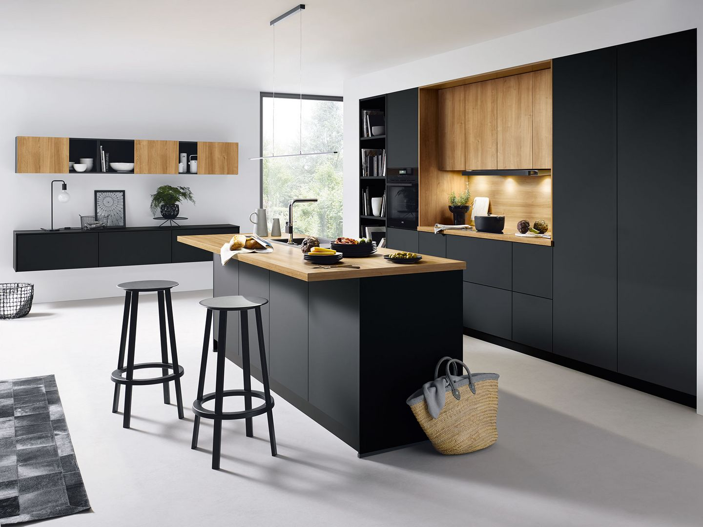 Schüller Inselküche mit dunklen Fronten, heller Holzoptik und zwei Sitzplätzen an der Insel