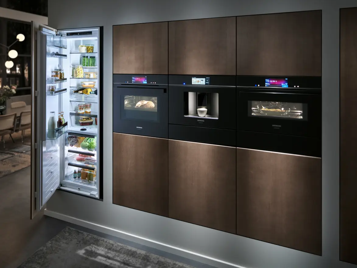 Gerätewand mit geöffnetem Kühlschrank, Backöfen und Einbau-Kaffeevollautomat in dunklen Fronten
